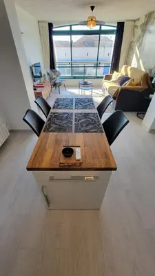 a table in a room with chairs and a living room at Le Tropical in Port-la-Nouvelle