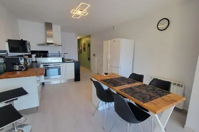 a kitchen with a wooden table and black chairs at Le Tropical in Port-la-Nouvelle
