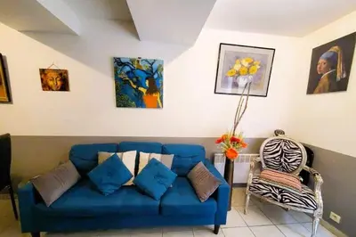 a blue couch and a chair in a living room at L'Occitane Maison de village climatisée in Lapalme