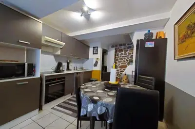 a kitchen with a table and chairs in a room at L'Occitane Maison de village climatisée in Lapalme