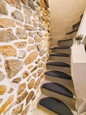a stone staircase in a house with a stone wall at L'Occitane Maison de village climatisée in Lapalme