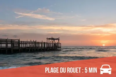 a pier with a car parked next to the ocean at L'Occitane Maison de village climatisée in Lapalme