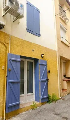 a building with blue doors on the side of it at L'Occitane Maison de village climatisée in Lapalme