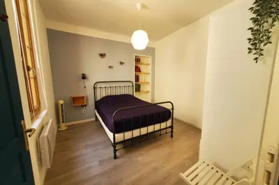 a bedroom with a bed in the corner of a room at La Louve in Narbonne