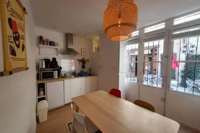 a kitchen with a wooden table and a dining room at La Louve in Narbonne