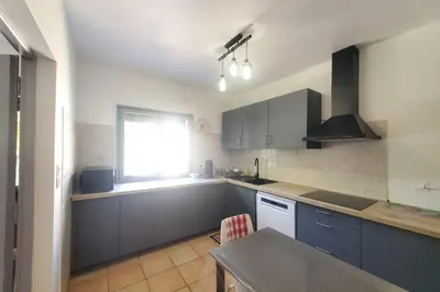 a kitchen with blue cabinets and a window at L'amandier - Maison avec jardin sans vis à vis in Port-la-Nouvelle