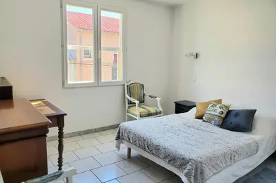 a bedroom with a bed and a desk and a window at L'amandier - Maison avec jardin sans vis à vis in Port-la-Nouvelle