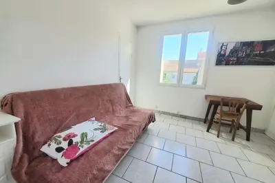 a living room with a couch with a pillow on it at L'amandier - Maison avec jardin sans vis à vis in Port-la-Nouvelle