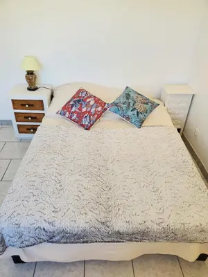a bed with two pillows on it in a bedroom at L'amandier - Maison avec jardin sans vis à vis in Port-la-Nouvelle