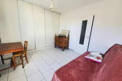 a room with a bed and a table and a desk at L'amandier - Maison avec jardin sans vis à vis in Port-la-Nouvelle