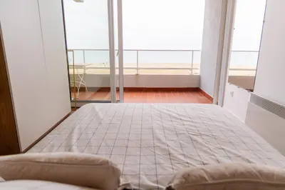 a large bed in a room with a large window at La Perle de la Mer in Port-la-Nouvelle