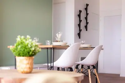 a dining room with a table and white chairs at La Perle de la Mer in Port-la-Nouvelle