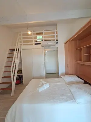 a bedroom with a bed and a stair case at L'Escapade ensoleillée - Pavillon pour 4 in Port-la-Nouvelle