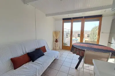 a living room with a white couch and a table at L'Escapade ensoleillée - Pavillon pour 4 in Port-la-Nouvelle