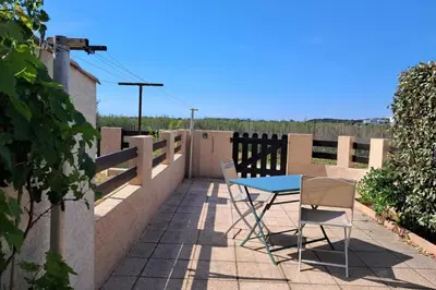 a table and two chairs on a balcony at L'Escapade ensoleillée - Pavillon pour 4 in Port-la-Nouvelle