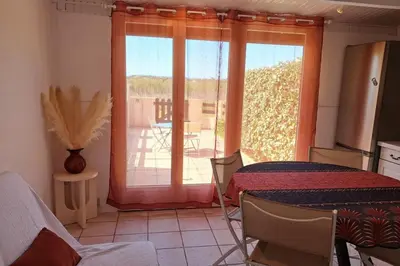a room with a table and a window with a patio at L'Escapade ensoleillée - Pavillon pour 4 in Port-la-Nouvelle