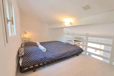 a bedroom with a bed in a room with a window at L'Escapade ensoleillée - Pavillon pour 4 in Port-la-Nouvelle