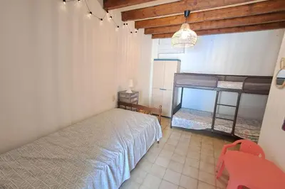 a bedroom with a bed and a bunk bed at L'Echo des étangs in Peyriac-de-Mer