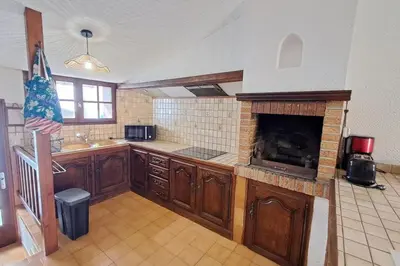 a kitchen with a fireplace in the middle of it at L'Echo des étangs in Peyriac-de-Mer