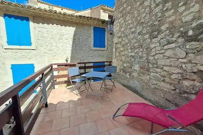 a patio with chairs and a table on a balcony at L'Echo des étangs in Peyriac-de-Mer