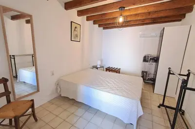 a bedroom with a white bed and a mirror at L'Echo des étangs in Peyriac-de-Mer