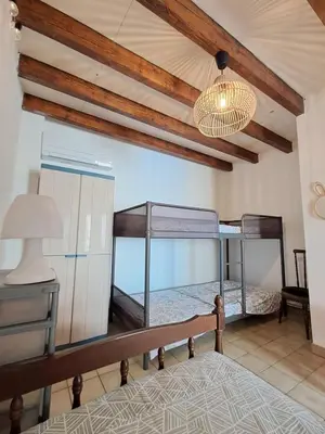 a bedroom with two bunk beds and a lamp at L'Echo des étangs in Peyriac-de-Mer