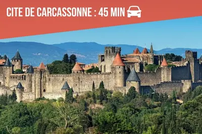 a large castle on a hill with mountains in the background at Gîte Studio Les Ecureuils in Narbonne