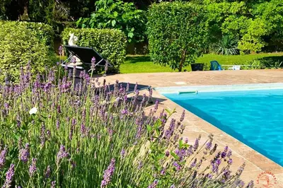 a person sitting in a chair next to a pool at Gîte Studio Les Ecureuils in Narbonne