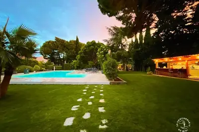a yard with a swimming pool and green grass at Gîte Studio Les Ecureuils in Narbonne
