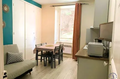 a small living room with a table and a couch at Gîte Studio Les Cigales piscine & WIFI in Narbonne