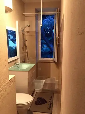 a bathroom with a toilet and a sink and a window at Gîte Studio Les Cigales piscine & WIFI in Narbonne
