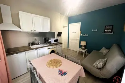 a small kitchen with a table and a dining room at Gîte Studio Les Cigales piscine & WIFI in Narbonne