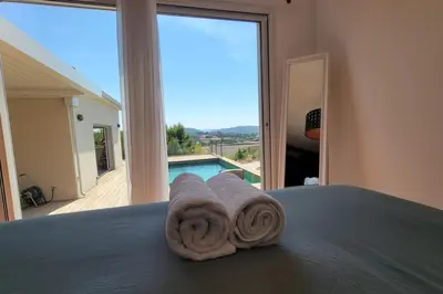 a bed with towels on it with a view of a pool at Villa Famara in Montredon