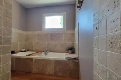 a bath tub in a bathroom with a window at Villa Famara in Montredon