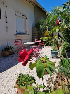 two red chairs and a table in a garden at L'évasion des Corbières in Portel-des-Corbières