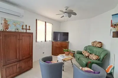 a living room with a green couch and two chairs at L'évasion des Corbières in Portel-des-Corbières