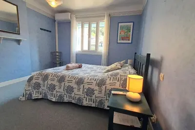 a bedroom with a bed and a table with a lamp at La Glycine in Portel-des-Corbières