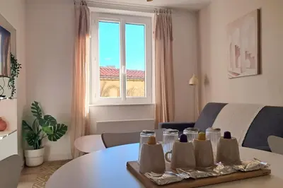 a living room with a table and a window at L'Olympe - Appartement cosy à 2 pas des Halles in Narbonne