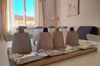 a table with a tray with some bottles and bags on it at L'Olympe - Appartement cosy à 2 pas des Halles in Narbonne