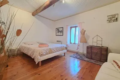 a bedroom with a bed and a wooden floor at Cigale piscine et jardin sans vis à vis in Fontcouverte