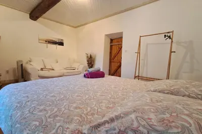 a bedroom with a large bed and a couch at Cigale piscine et jardin sans vis à vis in Fontcouverte