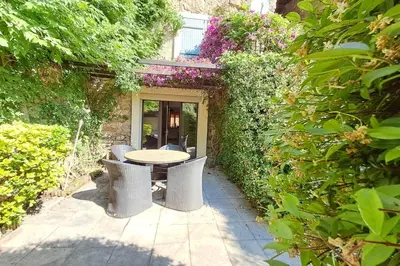 a patio with a table and chairs in a garden at Cigale piscine et jardin sans vis à vis in Fontcouverte
