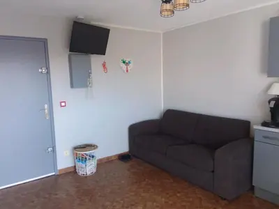 a living room with a couch and a tv at Les maisons sur la plage in Gruissan