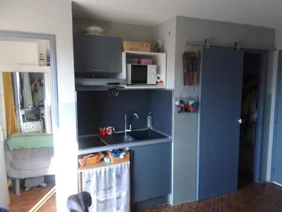 a kitchen with a sink and a microwave at Les maisons sur la plage in Gruissan