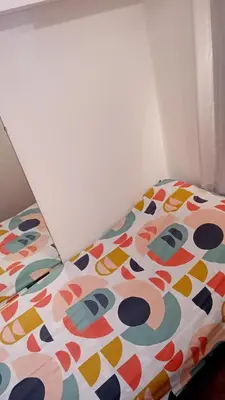a bed with a colorful comforter in a room at Les maisons sur la plage in Gruissan