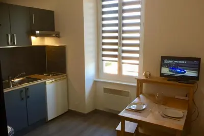 a small kitchen with a table and a window at Gîte Studio Les Oliviers in Narbonne