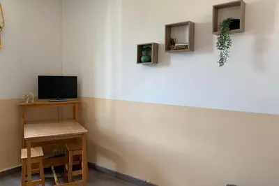 a corner of a room with a television and a table at Gîte Studio Les Oliviers in Narbonne