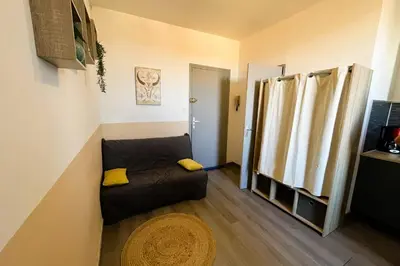 a small living room with a couch and a window at Gîte Studio Les Oliviers in Narbonne
