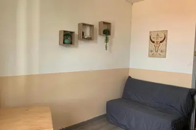a corner of a room with a blue couch at Gîte Studio Les Oliviers in Narbonne