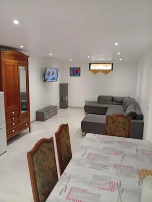 a living room with a bed and a table with chairs at Grand logement en souplex entier in Castres